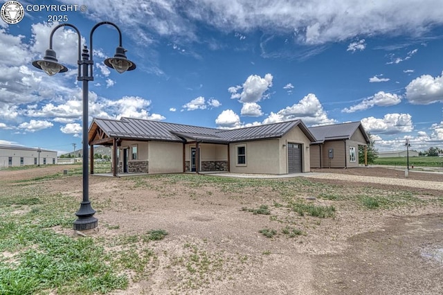 306 Fox Run E, Silver Cliff, CO 81252 - single story home with a garage, a metal roof, a standing seam roof, stucco siding, and dirt driveway