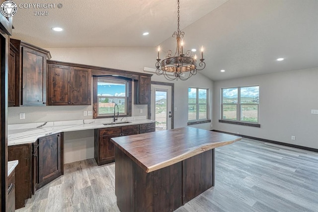 306 Fox Run E, Silver Cliff, CO 81252 - kitchen with vaulted ceiling, light wood-type flooring, a chandelier, wood counters, and dark brown cabinets