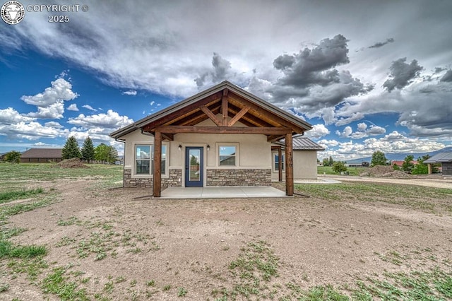 306 Fox Run E, Silver Cliff, CO 81252 - back of house with stucco siding, stone siding, and a patio