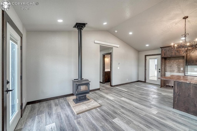 306 Fox Run E, Silver Cliff, CO 81252 - unfurnished living room with a wood stove, light wood finished floors, vaulted ceiling, a chandelier, and recessed lighting