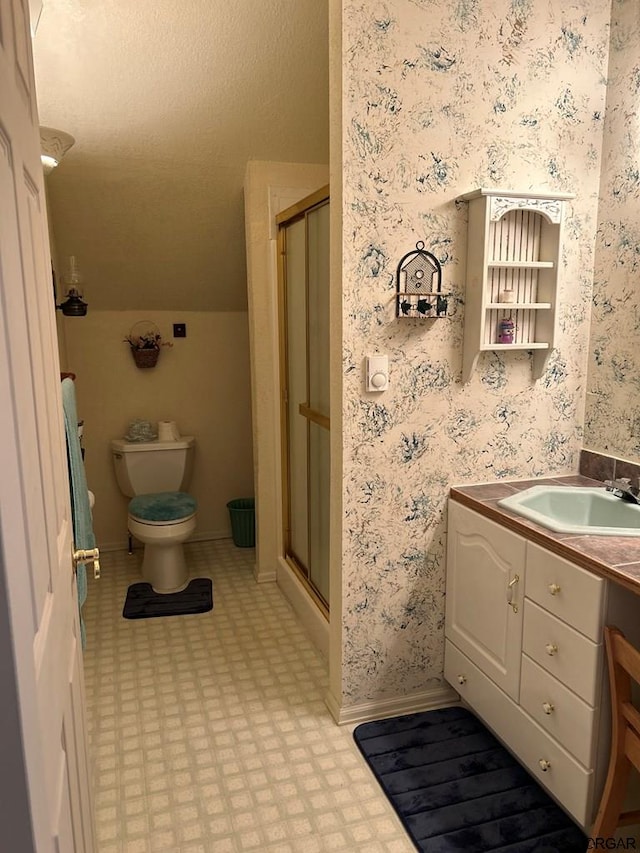 bathroom featuring vanity, a shower with shower door, and toilet