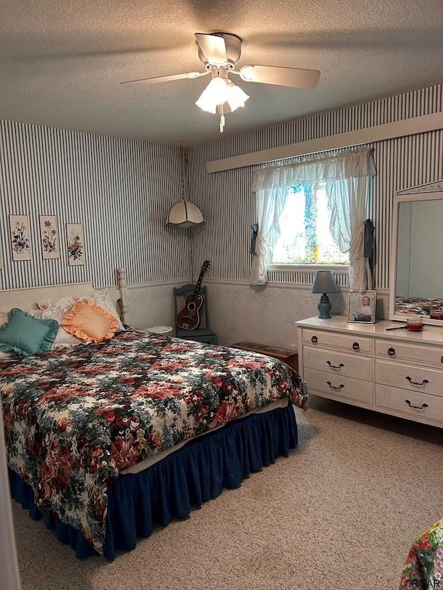 carpeted bedroom with ceiling fan and a textured ceiling