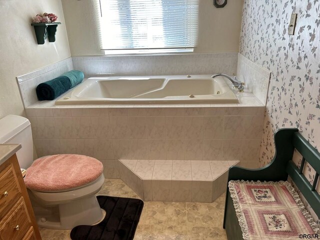 bathroom with a relaxing tiled tub, vanity, and toilet