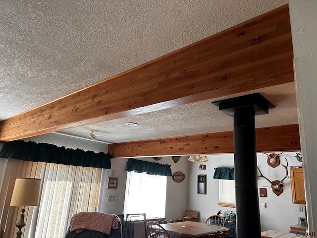 interior space featuring a wood stove and beam ceiling