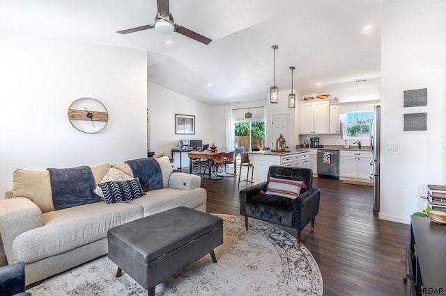 living room featuring ceiling fan, lofted ceiling, sink, and wood-type flooring