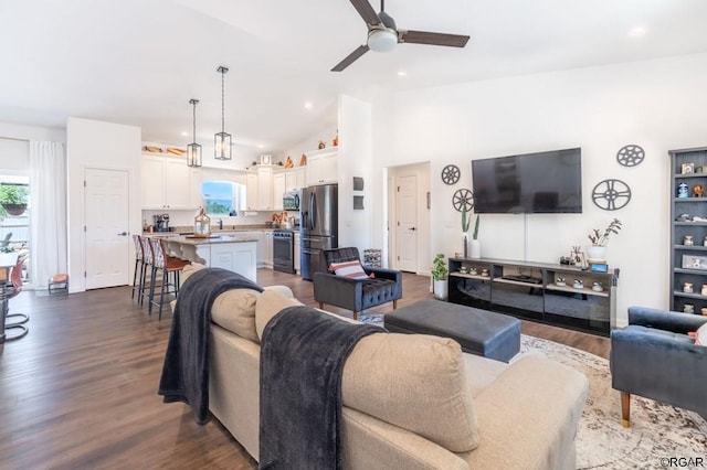 living room featuring ceiling fan, high vaulted ceiling, and dark hardwood / wood-style flooring