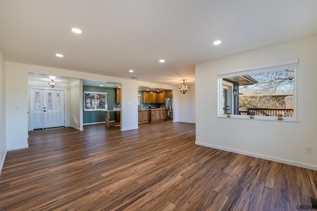 unfurnished living room with dark hardwood / wood-style flooring and a notable chandelier