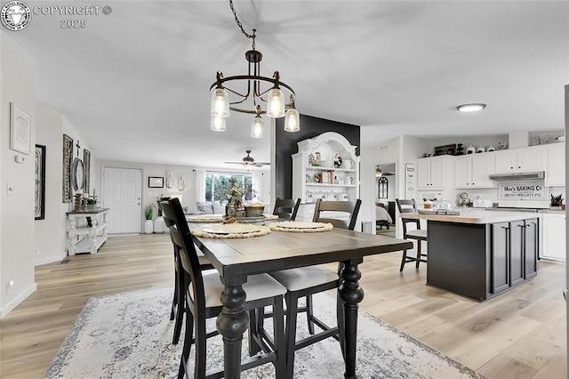 1431 Pine St, Canon City, CO 81212 - dining room featuring light wood-style floors, a ceiling fan, and a chandelier