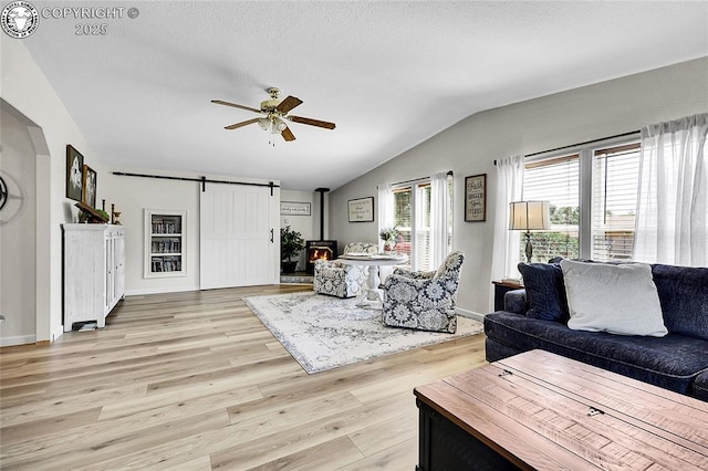 1431 Pine St, Canon City, CO 81212 - living room with lofted ceiling, light wood-type flooring, ceiling fan, a textured ceiling, and a barn door