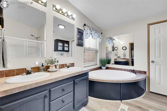 1431 Pine St, Canon City, CO 81212 - full bathroom with double vanity, a garden tub, an enclosed shower, wood finished floors, and vaulted ceiling