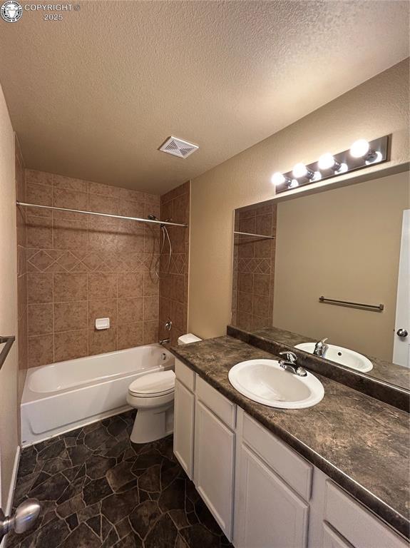 7465 Sun Prairie Dr, Colorado Springs, CO 80925 - full bath with vanity, shower / washtub combination, and a textured ceiling