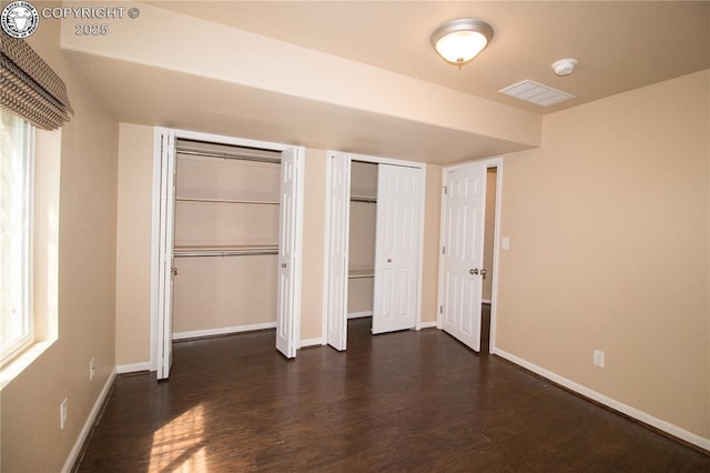 7465 Sun Prairie Dr, Colorado Springs, CO 80925 - unfurnished bedroom featuring dark wood-style floors and multiple closets