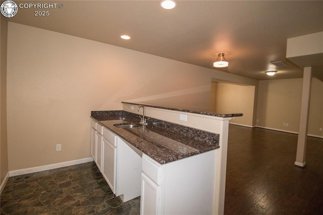 7465 Sun Prairie Dr, Colorado Springs, CO 80925 - kitchen with a peninsula, white cabinets, dark stone counters, and recessed lighting