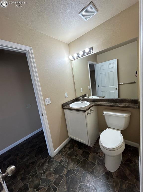 7465 Sun Prairie Dr, Colorado Springs, CO 80925 - bathroom with stone floors, vanity, and a textured ceiling