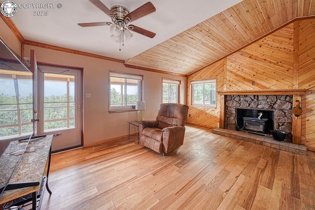 421 Bull Domingo Ln, Westcliffe, CO 81252 - living area featuring light wood-style flooring, a wood stove, vaulted ceiling, wooden walls, and ceiling fan