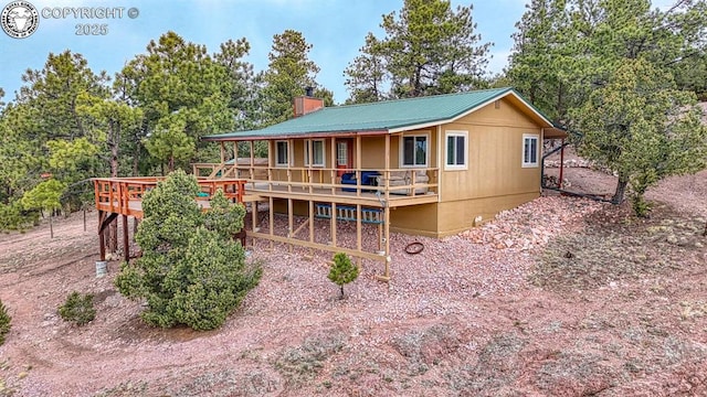 421 Bull Domingo Ln, Westcliffe, CO 81252 - back of property featuring a wooden deck, crawl space, a chimney, and a metal roof