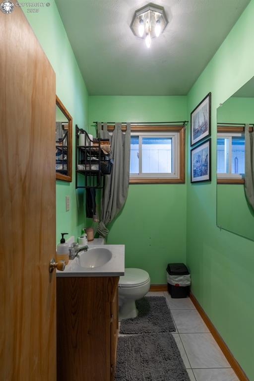 bathroom featuring baseboards, vanity, toilet, and tile patterned floors