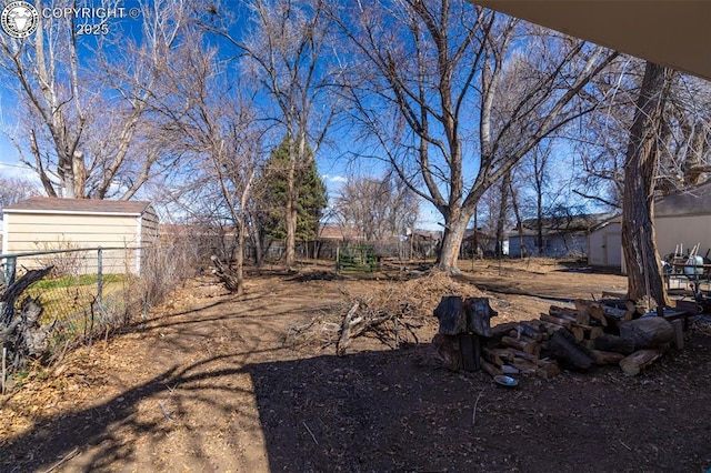 view of yard with a shed, an outdoor structure, and fence