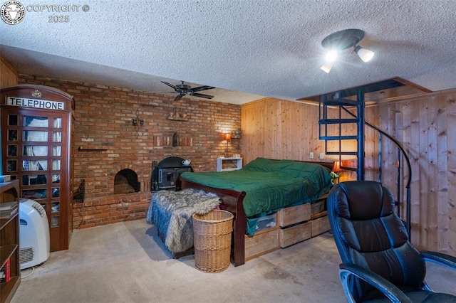 bedroom featuring a wood stove, wood walls, and a textured ceiling