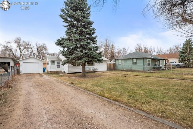 view of front facade with a front yard, fence, a garage, driveway, and an outdoor structure