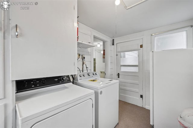 laundry area with washing machine and dryer, laundry area, and light carpet