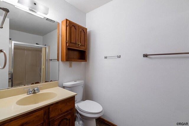 bathroom with vanity, an enclosed shower, and toilet