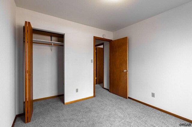 unfurnished bedroom featuring carpet flooring and a closet