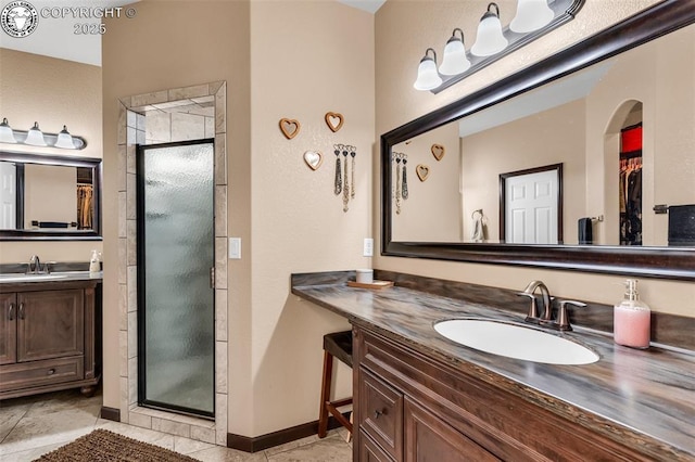 bathroom featuring tile patterned flooring, vanity, and walk in shower