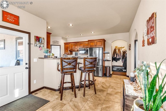 kitchen featuring a breakfast bar area, kitchen peninsula, and appliances with stainless steel finishes