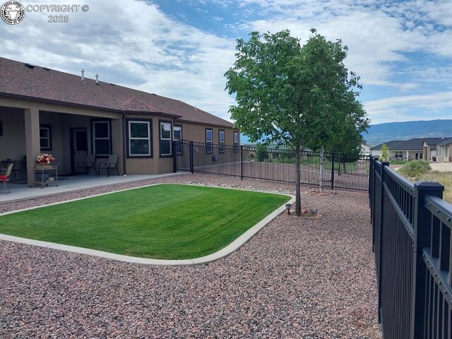 view of yard with a patio and a mountain view