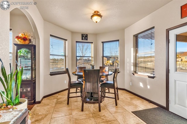 tiled dining room featuring a textured ceiling