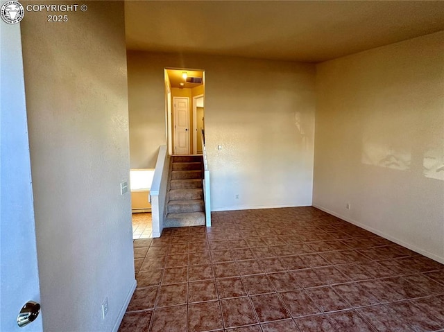 unfurnished room with dark tile patterned floors