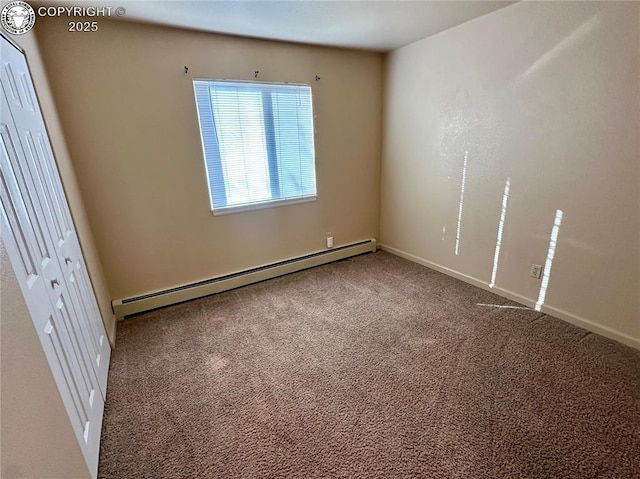 spare room featuring carpet floors and a baseboard heating unit