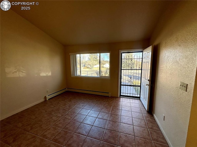 tiled empty room featuring vaulted ceiling and baseboard heating