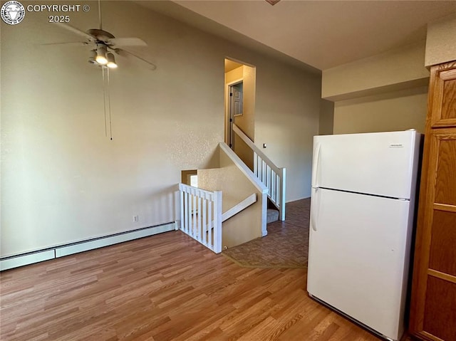 kitchen featuring ceiling fan, light hardwood / wood-style floors, white fridge, and a baseboard heating unit