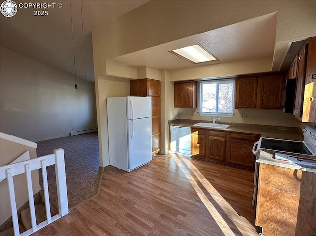 kitchen featuring a baseboard heating unit, wood-type flooring, sink, and white appliances