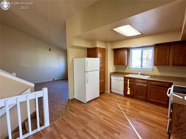 kitchen featuring sink, white appliances, a baseboard radiator, and light hardwood / wood-style floors