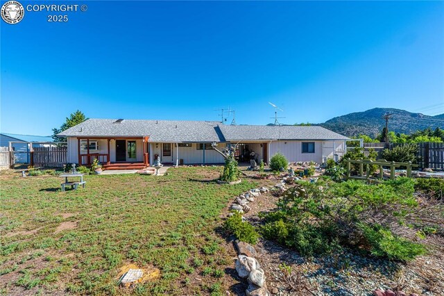 back of property featuring a yard and a mountain view