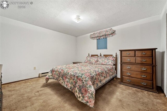 carpeted bedroom featuring a baseboard heating unit and a textured ceiling