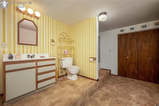 bathroom with vanity, toilet, and a textured ceiling