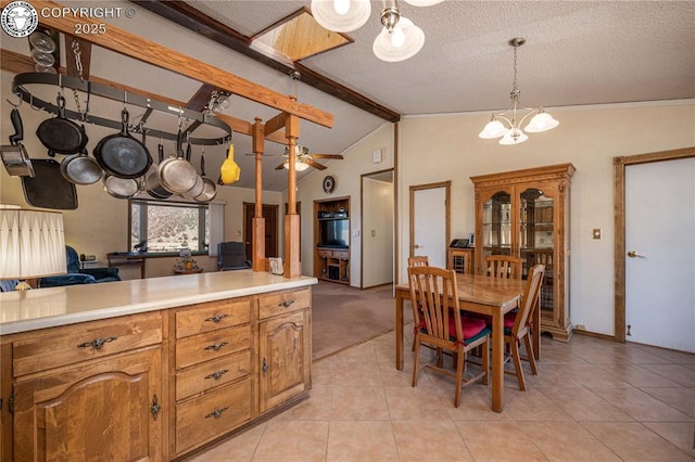 kitchen featuring vaulted ceiling with beams, decorative light fixtures, a chandelier, a textured ceiling, and light tile patterned floors