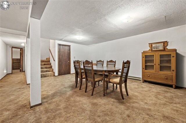 carpeted dining area with a textured ceiling and baseboard heating