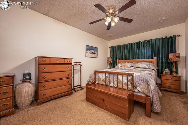 bedroom with ceiling fan, light carpet, and a textured ceiling