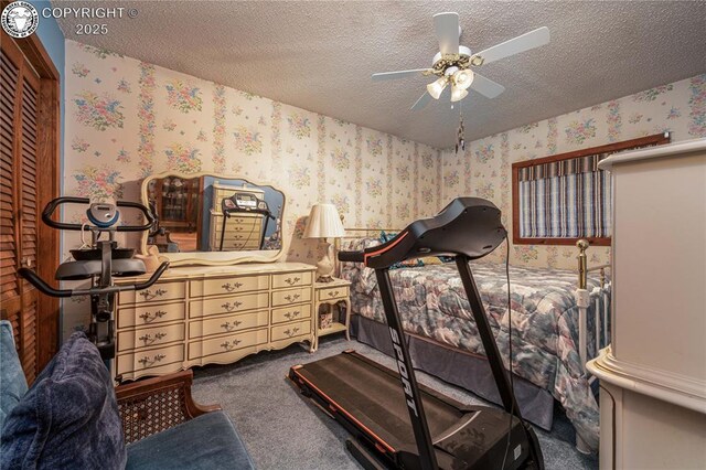 bedroom featuring carpet flooring, a textured ceiling, ceiling fan, and a closet