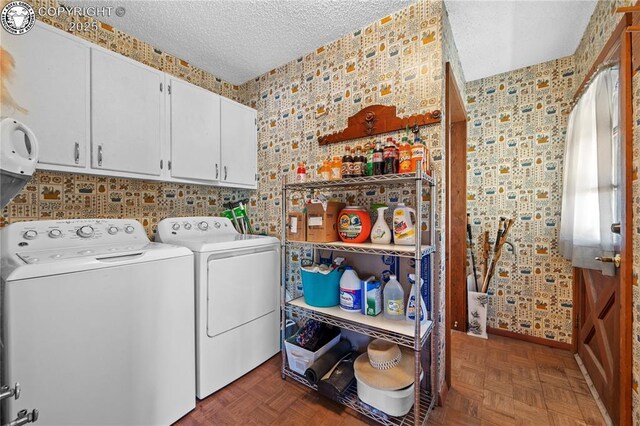 laundry area featuring cabinets, a textured ceiling, washing machine and clothes dryer, and dark parquet floors