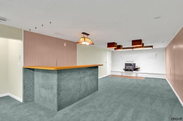 kitchen featuring pendant lighting, kitchen peninsula, a textured ceiling, and dark colored carpet