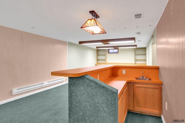 kitchen with sink, dark colored carpet, hanging light fixtures, kitchen peninsula, and a baseboard heating unit