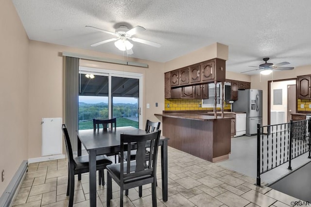 dining space with a textured ceiling, ceiling fan, and baseboard heating