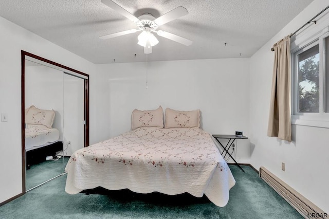 bedroom featuring baseboard heating, ceiling fan, dark carpet, and a closet