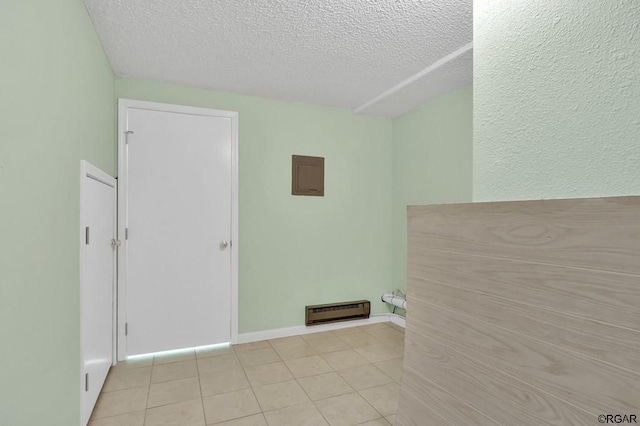 tiled empty room featuring electric panel and a textured ceiling